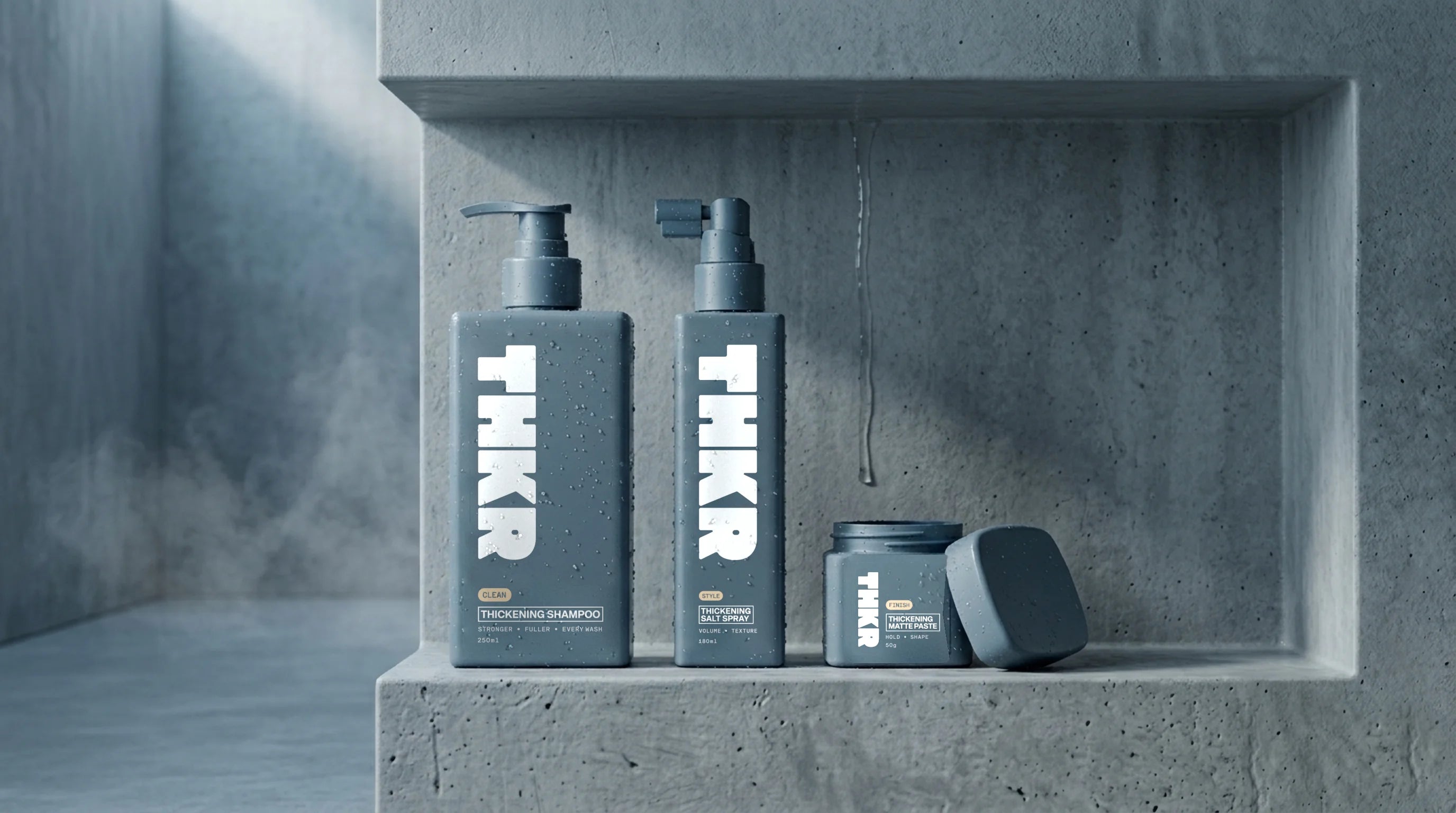 THKR thickening shampoo, salt spray and matte paste on a shower shelf.